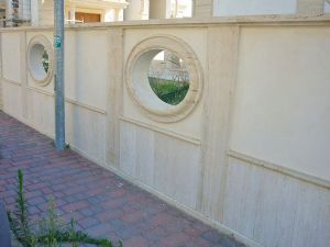 Rivestimento muro di recinzione in Travertino grezzo a poro aperto e acidato con obl scorniciati.