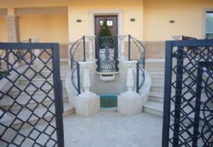 Ingresso villa in Travertino Chiaro in Falda Stuccato e Spazzolato (pavimento, colonnine, fontana, scala sagomata a misura a ventaglio).